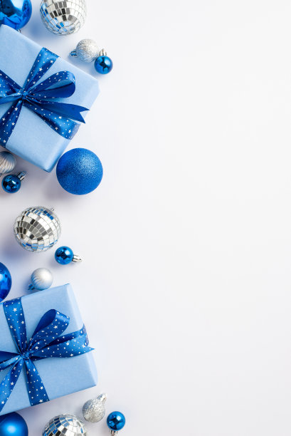 平安夜的概念。顶视图垂直照片目前的盒子丝带蝴蝶结蓝色白色银饰和迪斯科球孤立的白色背景与空白图片下载