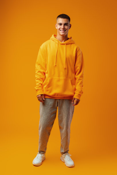 全幅肖像的年轻人站在黄色的背景图片下载