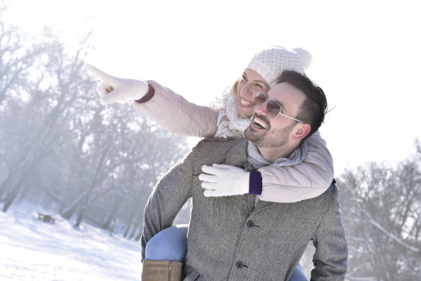 快乐的白人夫妇在雪原上享受背骑图片下载
