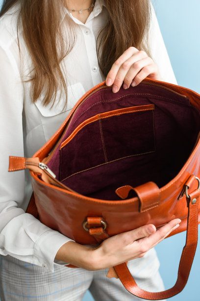 一个女人手里的橙色皮包的特写照片图片下载