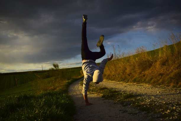 一个穿着灰色卫衣的男人在森林里跳舞的迷人镜头图片下载