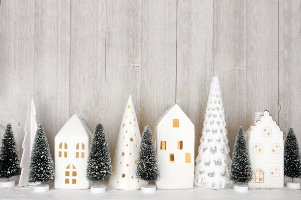 圣诞树装饰和架子上的白色房子，靠在质朴的灰色墙壁上图片下载