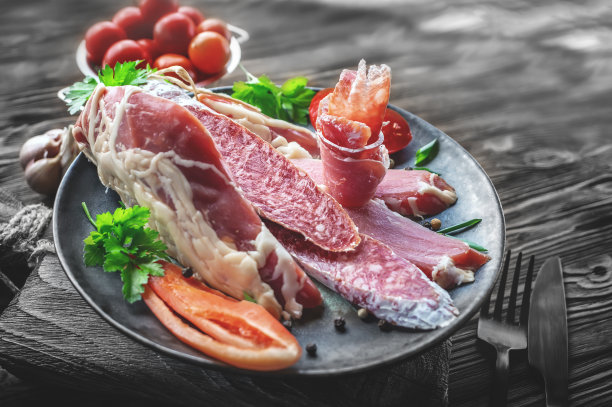 意大利肉菜。干肉和香肠放在厨房板上。意大利腊肠切片配番茄和黄辣椒粉的特写图片下载