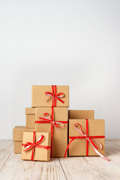 节礼日，白色木桌上摆放着一大堆装在纸板箱里的礼物图片下载