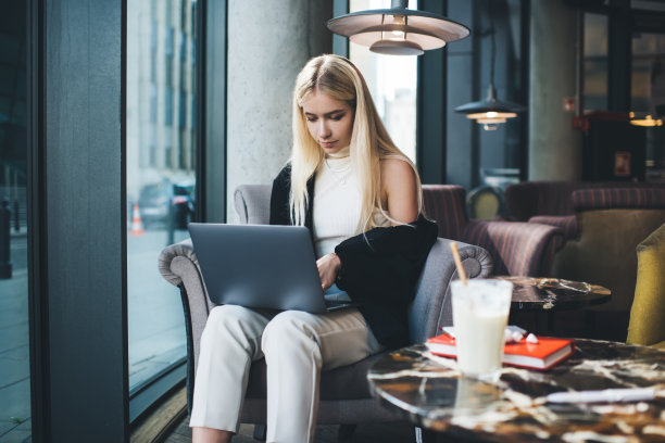 专注的女性在咖啡馆使用笔记本电脑图片下载