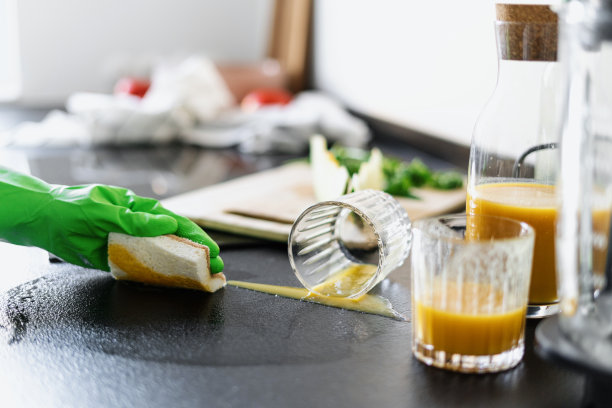 清洁厨房的人有脏的台面，玻璃杯和器具图片下载
