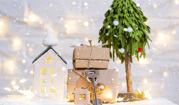 钥匙的房子与钥匙链上一个舒适的家与圣诞装饰。新年、圣诞节的礼物。建筑，设计，工程，搬迁到新房子，抵押，租赁和购买房地产图片下载