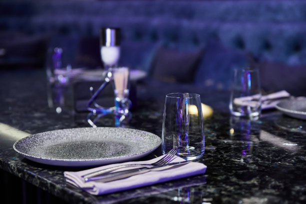 玻璃杯，叉子，刀，餐巾在餐厅的晚餐与舒适的内部图片下载