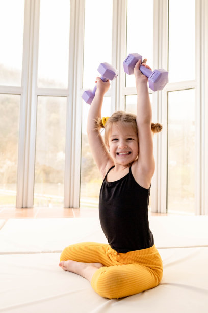 金发小女孩举哑铃，玩得很开心图片下载