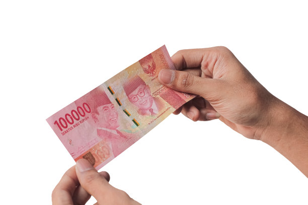 手里拿着白色背景上孤立的10万印尼盾纸币。金融概念图片下载