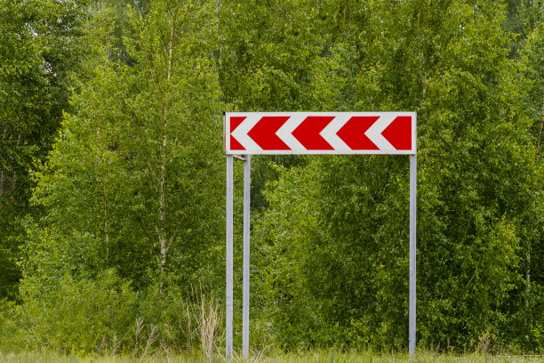 绿色背景上的路标急转。图片下载