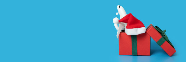 机票作为圣诞礼物，冬季旅行，圣诞假期，一架飞机在圣诞老人的帽子在圣诞礼物盒图片下载