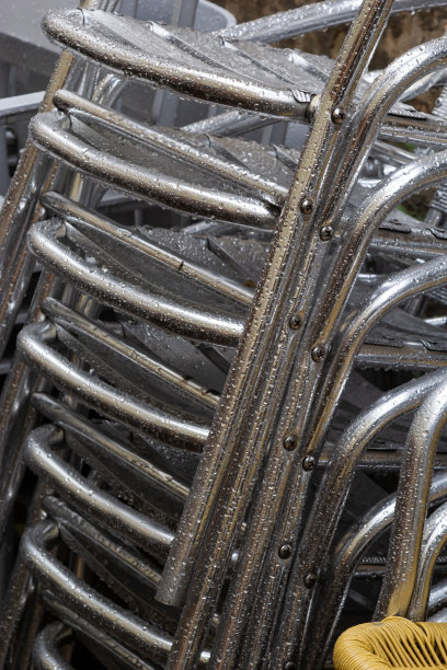 椅子折叠。咖啡馆前的不锈钢抛光桌子被雨水和露水打湿了。户外露台的季节结束了图片下载