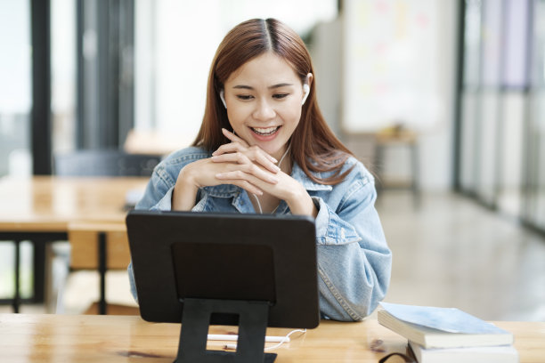 年轻女学生使用平板电脑在线学习。图片下载