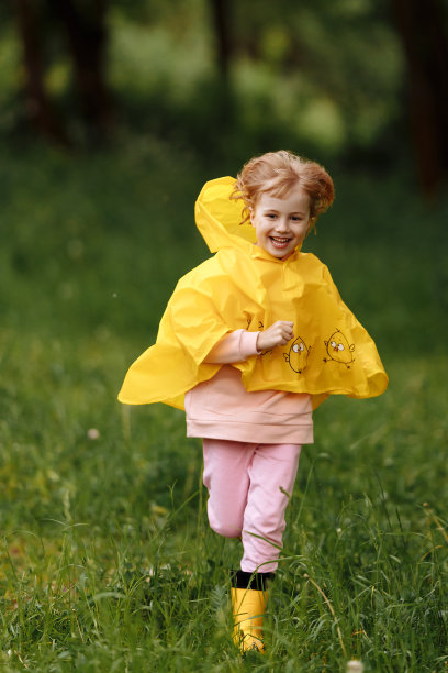 秋雨下快乐有趣的宝贝。女孩在雨中欢快地奔跑，欢笑图片下载