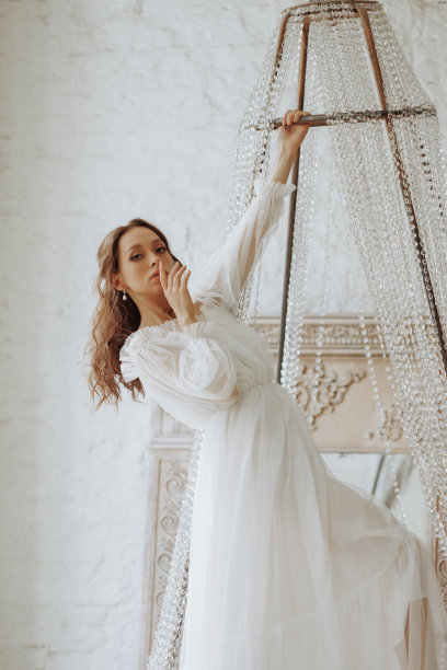 穿着白裙子的漂亮女孩在枝形吊灯上荡秋千图片下载