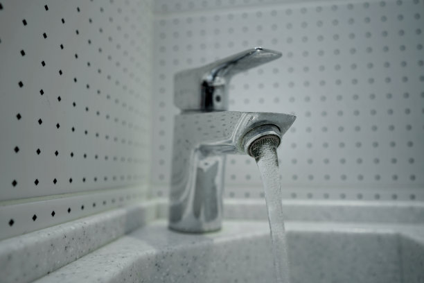 钢制银水龙头，有发霉的喷嘴和水流图片下载