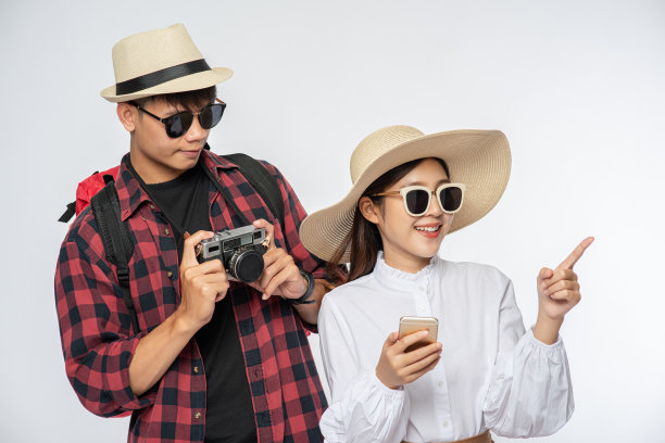 男男女女穿着旅行的衣服，戴着眼镜，拍照。图片下载