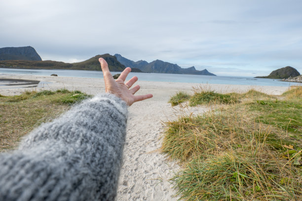 POV，女性的手伸向田园诗般的海滩图片下载