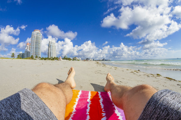 POV视角拍摄的一个年轻人看着一个波在他的脚在天堂景观蓝色的海在南海滩，迈阿密海滩，南佛罗里达州，美国图片下载