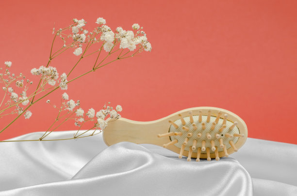 木梳放在丝绸做的台子上。广告梳子或美发师的照片图片下载