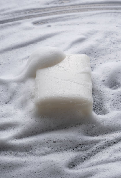 在泡沫的背景上放置固体肥皂。图片下载