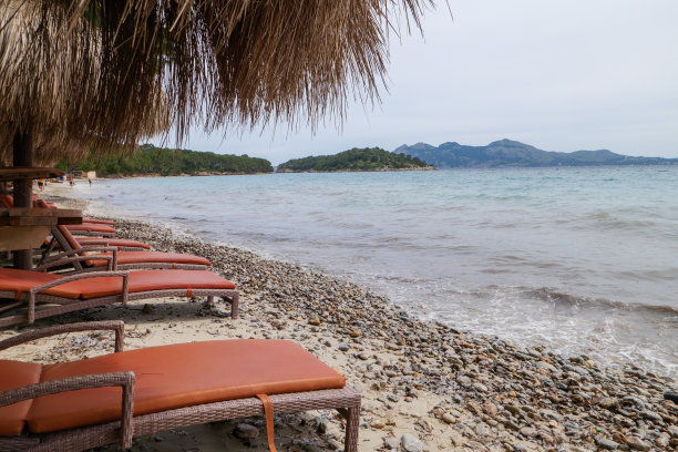 西班牙马略卡岛巴利阿里群岛的福蒙特半岛海滩上的日光浴床和雨伞图片下载