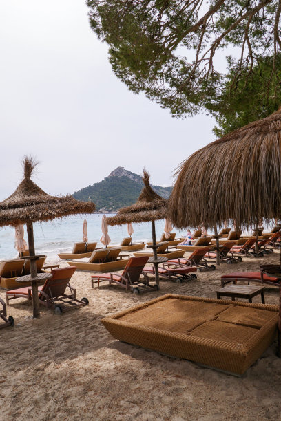 西班牙马略卡岛巴利阿里群岛的福蒙特半岛海滩上的日光浴床和雨伞图片下载