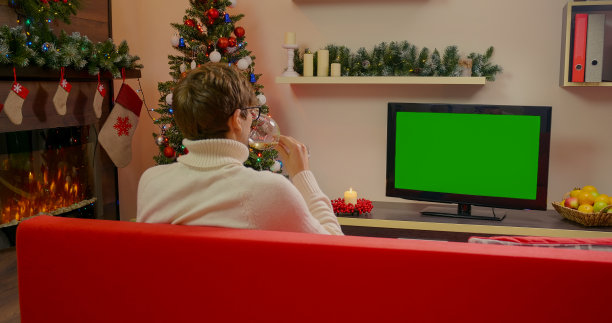 男人正在看绿幕电视，喝着一杯酒图片下载