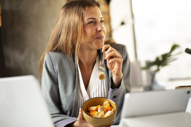 年轻女子一边吃水果一边打视频电话。图片下载