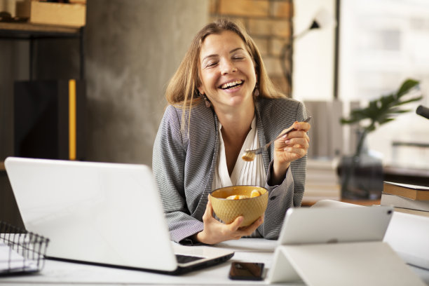 年轻女子一边吃水果一边打视频电话。图片下载
