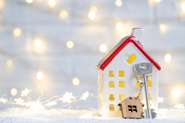 钥匙的房子与钥匙链上一个舒适的家与圣诞装饰。新年、圣诞节的礼物。建筑，设计，工程，搬迁到新房子，抵押，租赁和购买房地产图片下载