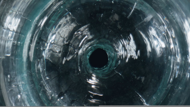 旋转饮料旋转玻璃器皿特写。清凉的水在玻璃高脚杯中旋转图片下载