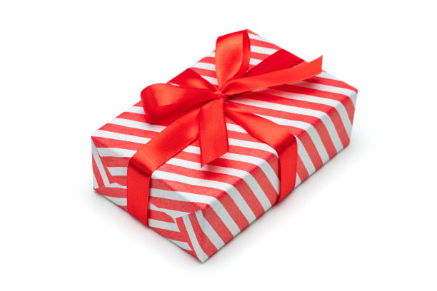 特写镜头的礼物盒包装在红白条纹纸和装饰蝴蝶结，孤立在白色背景图片下载