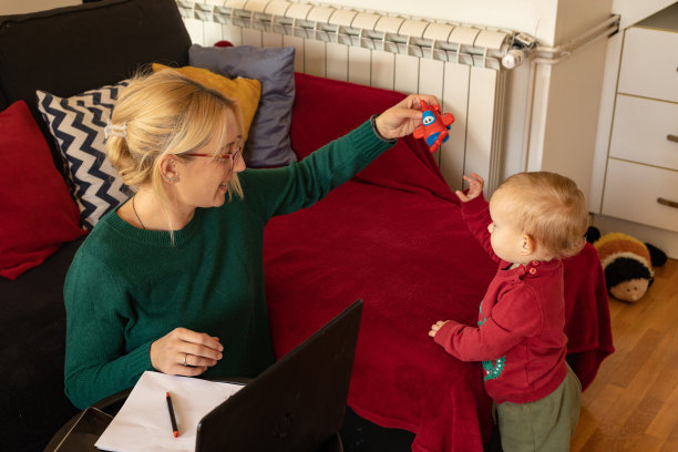 当妈妈在家工作时，小婴儿试图引起妈妈的注意图片下载