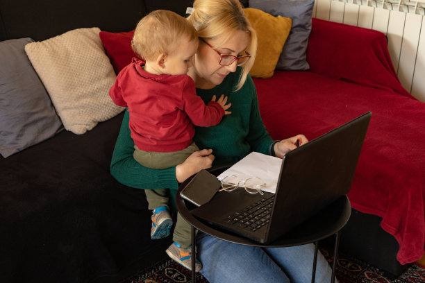 当妈妈在家工作时，小婴儿试图引起妈妈的注意图片下载