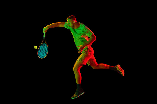 年轻的运动男子，职业网球运动员在运动，行动孤立在霓虹灯的黑暗背景。职业体育的概念，比赛，技巧。图片下载