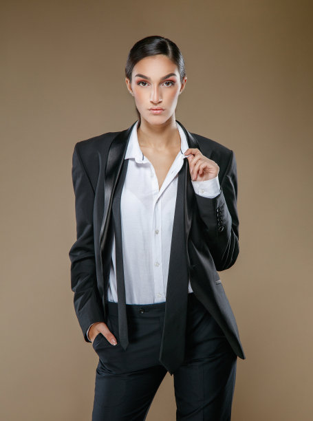 肖像美丽的年轻褐发在黑色长裤套装和白色纽扣衬衫看着相机图片下载