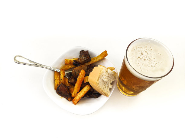 一杯新鲜啤酒的特写照片和一份猪肉和土豆的开胃酒图片下载