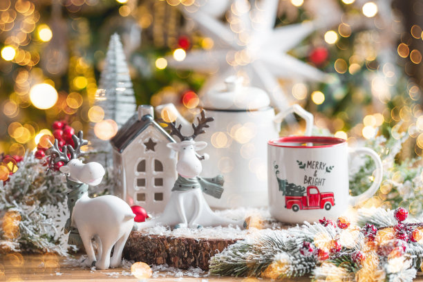 一张有可爱驯鹿的圣诞卡和一杯以美丽的焦景为背景的热咖啡。新年静物画。家庭度假的概念，温馨和舒适。图片下载