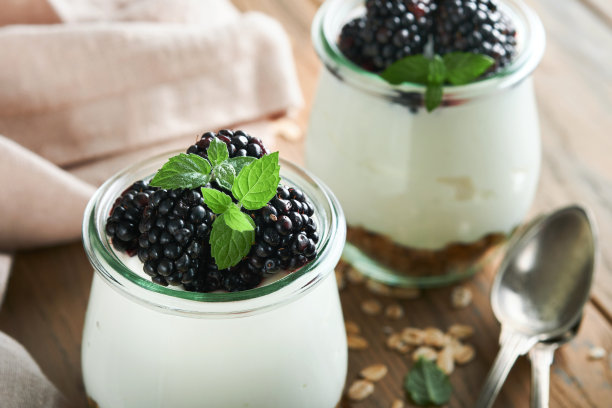 酸奶配格兰诺拉麦片，黑莓浆果水果和什锦麦片，装在木制背景的玻璃罐中。健康早餐的概念。健康的早餐，俯视图图片下载