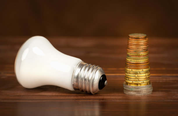 带有硬币的灯泡，节能或高效的背景图片下载