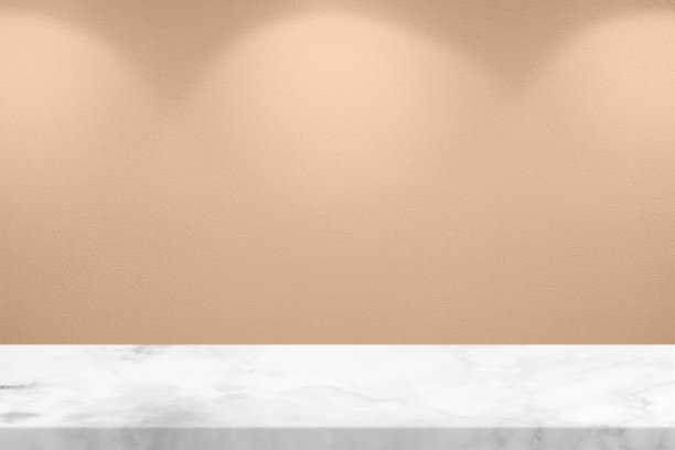 白色大理石桌子和金色玫瑰灰泥墙背景与聚光灯从顶部。图片下载