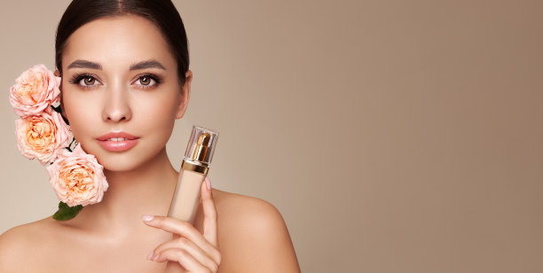 美丽的年轻女子与粉底瓶和玫瑰花图片下载