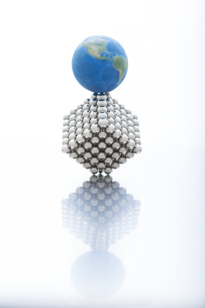 人工微模型，大量的金属磁球整齐地排列成一个立方体和一个地球模型在它上面图片下载