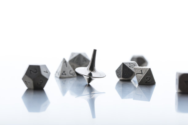 人工微模型，一些金属多面体骰子与旋转金属陀螺仪图片下载