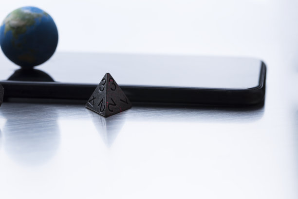 人工微模型，金属正四面体骰子和智能手机屏幕上的地球模型图片下载