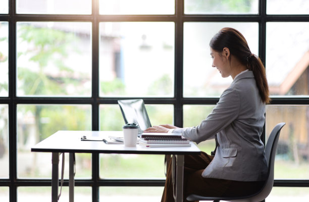 年轻的亚洲女商人在办公室用笔记本电脑和会计工作。图片下载