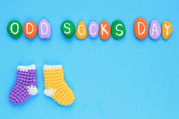 奇怪的袜子天字母和不匹配的彩色袜子在蓝色背景。社会学校欺凌的概念。图片下载