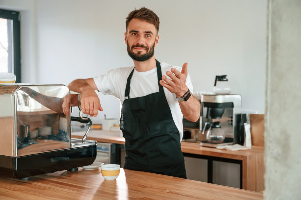 美丽的肖像。穿着白衬衫和黑围裙的咖啡馆工作人员在室内图片下载
